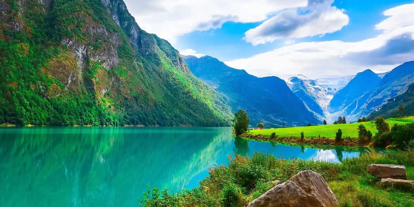 A scenic view of Sognefjord, Norway, featuring deep blue fjord waters surrounded by steep, green mountains