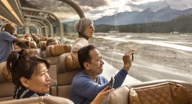 A couple taking a photo whilst onboard the Rocky Mountaineer in Canada
